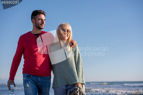 Image of Loving young couple on a beach at autumn sunny day