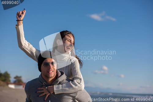 Image of couple having fun at beach during autumn