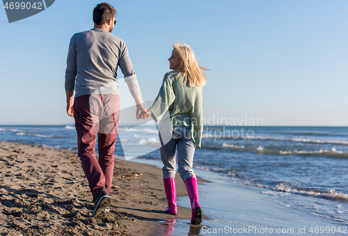 Image of Loving young couple on a beach at autumn sunny day