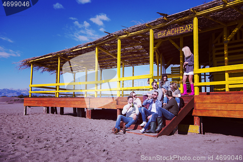 Image of Group of friends having fun on autumn day at beach