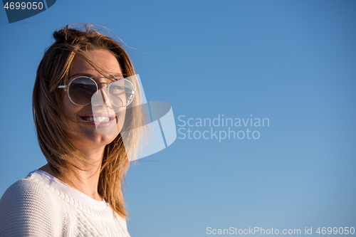 Image of Young woman enjoying the warm autumn day