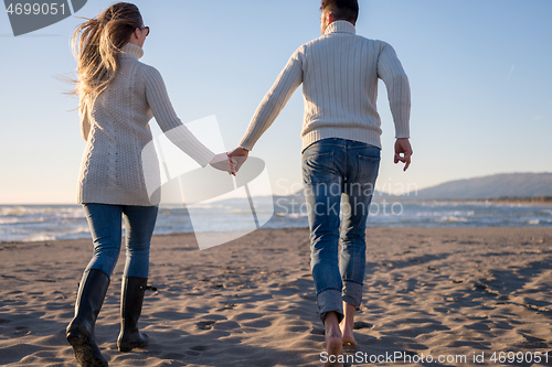 Image of Loving young couple on a beach at autumn sunny day