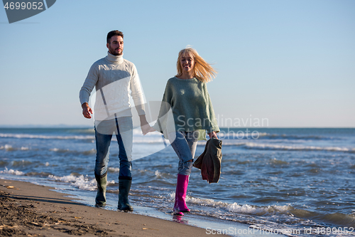 Image of Loving young couple on a beach at autumn sunny day