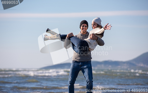 Image of Loving young couple on a beach at autumn sunny day