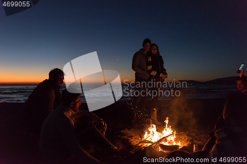 Image of Friends having fun at beach on autumn day