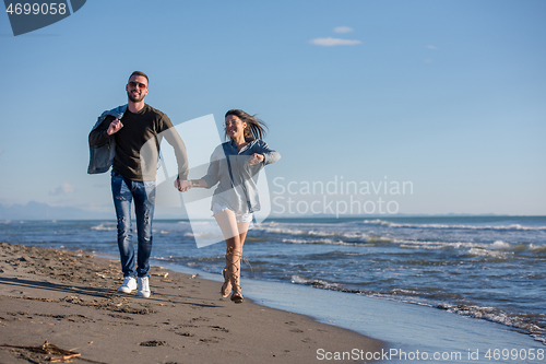 Image of Loving young couple on a beach at autumn sunny day