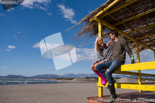 Image of young couple drinking beer together at the beach