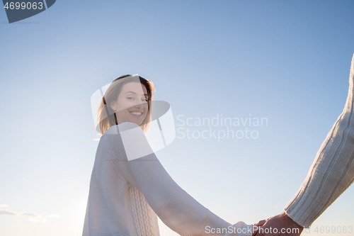 Image of Loving young couple on a beach at autumn sunny day