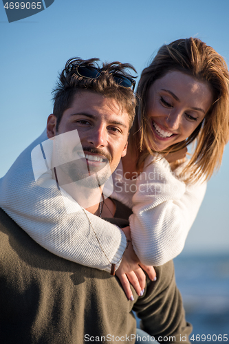 Image of couple having fun at beach during autumn