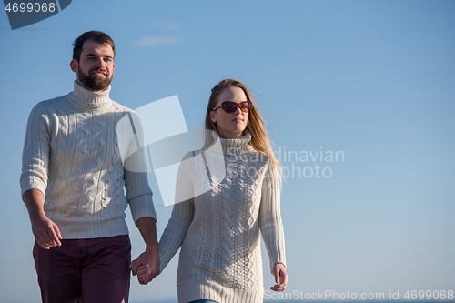 Image of Loving young couple on a beach at autumn sunny day