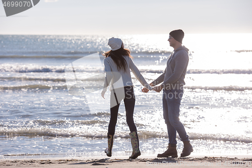 Image of Loving young couple on a beach at autumn sunny day