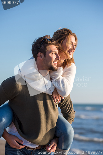 Image of couple having fun at beach during autumn