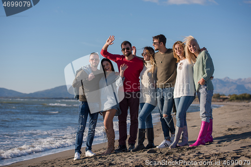 Image of portrait of friends having fun on beach during autumn day