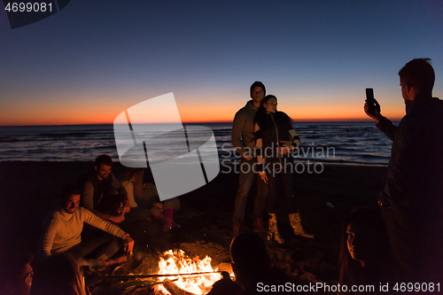 Image of Friends having fun at beach on autumn day