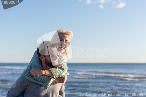 Image of couple having fun at beach during autumn