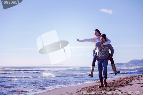 Image of couple having fun at beach during autumn