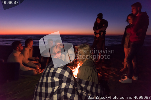 Image of Couple enjoying with friends at sunset on the beach