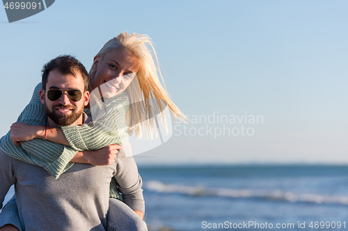 Image of couple having fun at beach during autumn