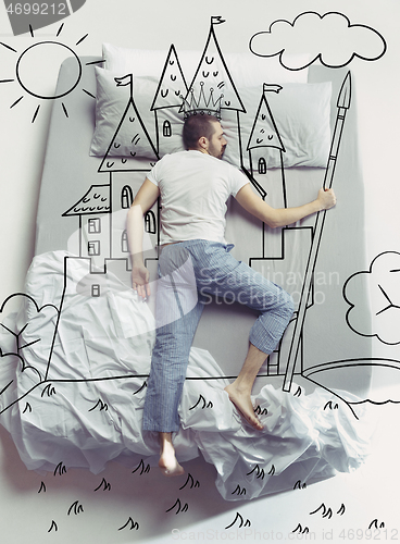 Image of Top view photo of young man sleeping in a big white bed and his dreams