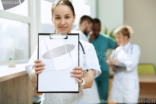 Image of Beautiful smiling doctor over hospital background