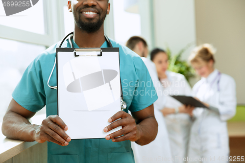 Image of Beautiful smiling african doctor over hospital background