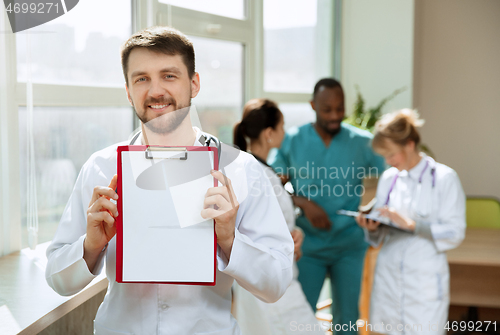 Image of Beautiful smiling doctor over hospital background