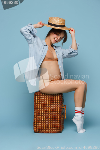 Image of Young beautiful pregnant woman posing on blue background