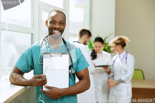 Image of Beautiful smiling african doctor over hospital background