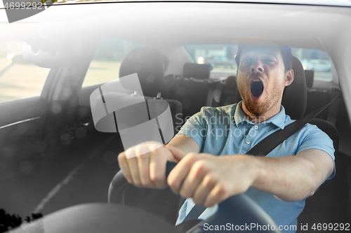 Image of tired sleepy man or driver driving car and yawning