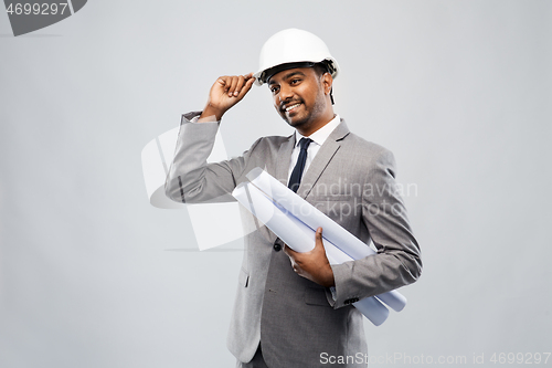 Image of indian male architect in helmet with blueprints