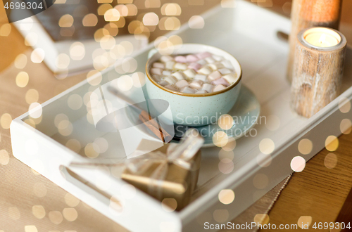 Image of hot chocolate, christmas gift and candles on table