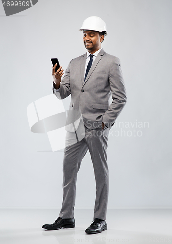 Image of indian male architect in helmet with smartphone