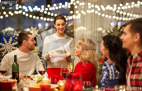 Image of happy friends having christmas dinner at home