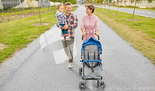 Image of family with baby and stroller walking along city