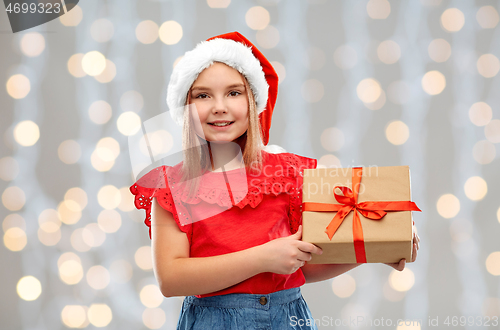 Image of smiling girl in santa hat with christmas gift