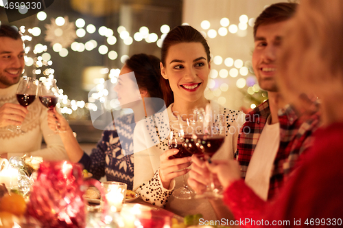 Image of happy friends celebrating christmas at home feast