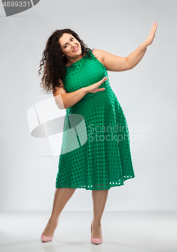 Image of happy woman in green dress over posing