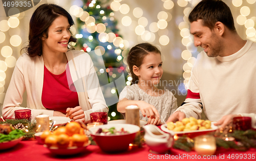 Image of happy family having christmas dinner at home