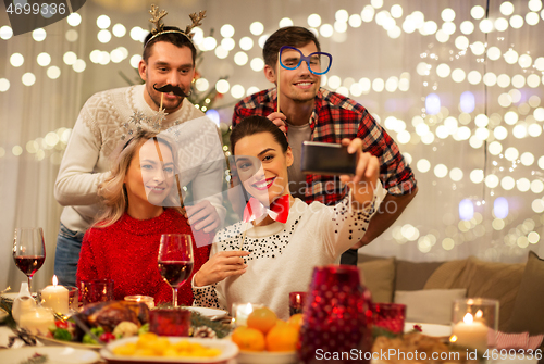 Image of friends taking selfie at christmas dinner