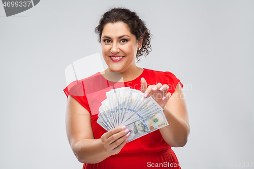 Image of happy woman holding hundreds of money banknotes