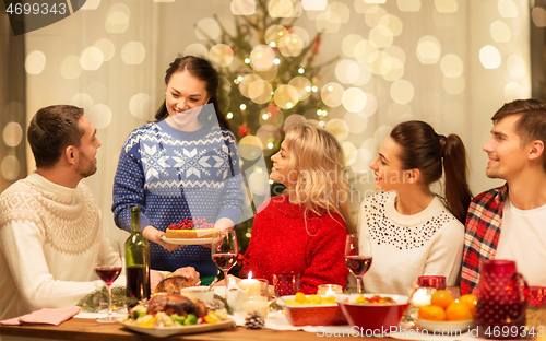 Image of happy friends having christmas dinner at home