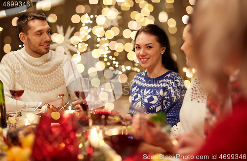 Image of happy friends having christmas dinner at home