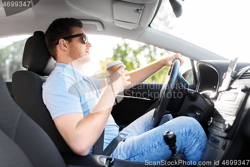 Image of man or driver with takeaway coffee cup driving car