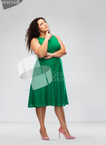 Image of serious woman in green dress thinking