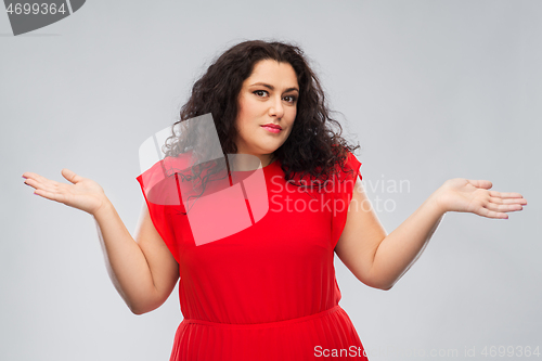 Image of woman in red dress shrugging over grey background