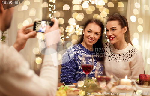 Image of friends having christmas dinner and taking picture