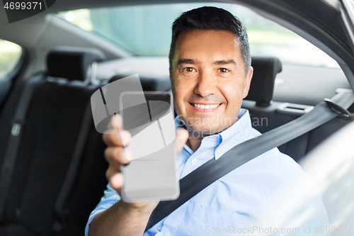 Image of passenger or businessman showing smartphone in car