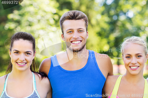 Image of group of happy friends or sportsmen at summer park