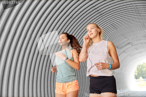 Image of women or female friends with earphones running