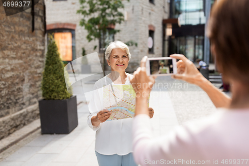 Image of senior women with city map on street in tallinn